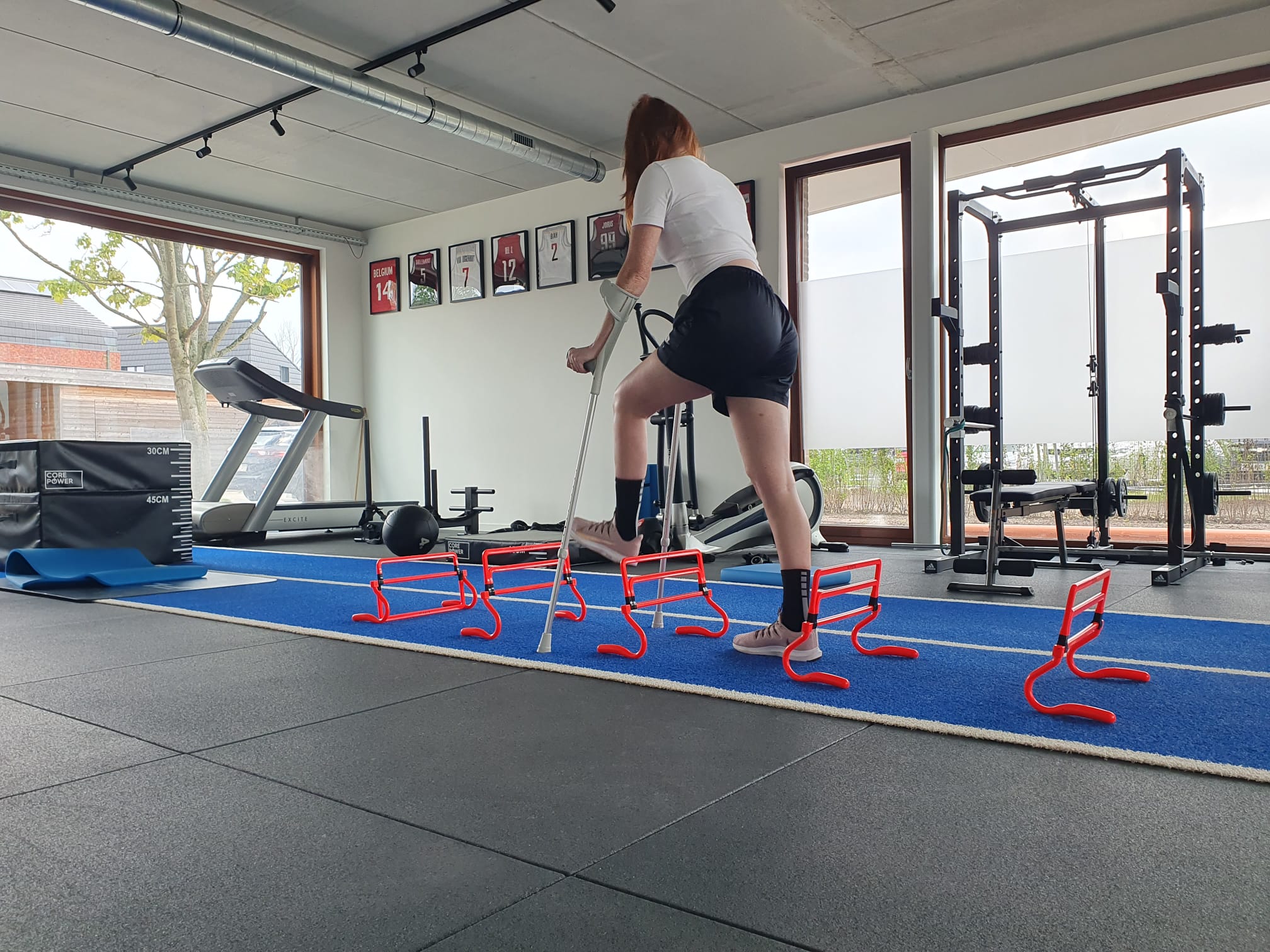 Een persoon met sportkleren aan die loopt op een indoor track piste.